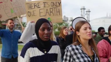Küresel iklim değişikliği grevinde pankartlı ve posterli çeşitli çok ırklı insanlar. Küresel ısınma ve çevre kavramı.