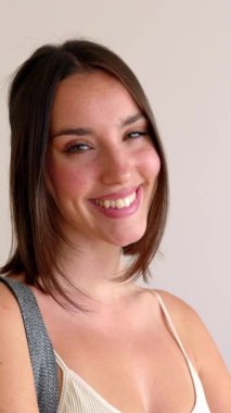 Evde kameraya gülümseyen yoga minderli güzel bir kadının dikey HD video portresi. Spor, spor salonu ve aktif insanlar konsepti.