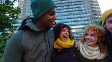 Genç bir grup insan kış günü dışarıda birlikte eğleniyor. Sıcak giyimli çok ırklı en iyi arkadaşlar şehir caddesinde birlikte vakit geçiriyorlar. Birleşik Milenyum öğrencileri gülüyor.