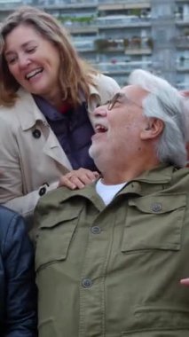 Dışarıda birlikte otururken gülen mutlu emeklilerin olduğu dikey HD videosu. Yaşlı olgun insan yaşam tarzı konsepti.