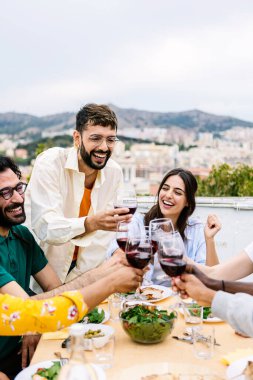 Bir grup genç arkadaş terasta yemek yiyor. Milenyum insanları yaz partisi kutlamalarında masada oturarak eğleniyor. Arkadaşlık kavramı
