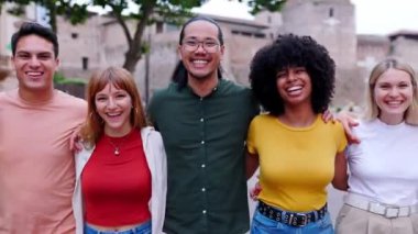 Sokakta birlikte yürürken kameraya gülümseyen bir grup çok ırklı genç arkadaş. Birleşmiş Milenyum insanları birbirlerine sarılıp birlik ve sevgi gösteriyorlar. Arkadaşlık ve gençlik toplumu kavramı. 