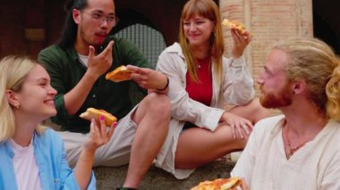 Farklı arkadaş grupları, İtalya 'da yaz tatilinin tadını çıkarırken birlikte pizza yiyorlar..