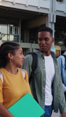 Sınıftan çıktıktan sonra kampüsten ayrılan çeşitli genç Latin Amerikalı öğrencilerin gülerek güldüğü dikey HD videolar. Çeşitlilik ve eğitim yaşam tarzı konsepti.