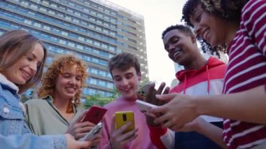 Dışarıda cep telefonu kullanan genç bir grup insan. Milenyum arkadaşları sosyal medya uygulaması, bahis ya da video oyunu bağımlısı. Gençlik toplumu ve teknoloji kavramı
