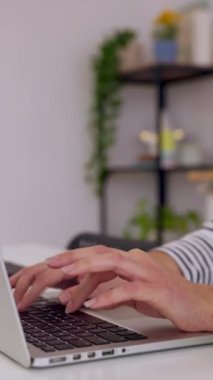 Dikey HD video: ofiste oturan bilgisayarda yazan kadın ellerini kapat. Evde dizüstü bilgisayarla çalışan genç bir kadın. Teknoloji yaşam tarzı konsepti