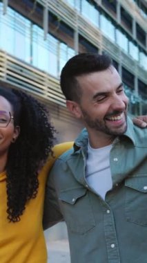 Şehir caddesinde birlikte eğlenen çok ırklı bir grup genç arkadaşın dikey HD videosu. Arkadaşlık yaşam tarzı konsepti