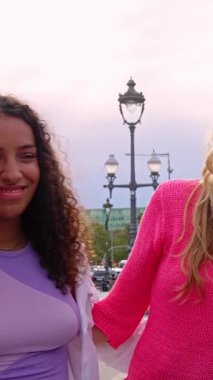 Şehrin sokaklarında gülen ve eğlenen bir grup mutlu kadının dikey HD videosu. Çok ırklı bayan arkadaşlar birlikte dışarıda vakit geçiriyorlar. Gençlik ve kız topluluğu konsepti.