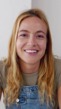 Bilgisayarda çalışan genç ve güzel bir kadının POV 'u. Ev telefonuyla iş arkadaşını dinliyor. Sanal toplantı konferansına katılan gülümseyen bir kadının vesikalık fotoğrafı. Dikey HD video