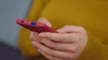 Genç bir kadının cep telefonuyla online mesaj yazışına, internete göz atmasına, sosyal medya için akıllı telefon uygulaması kullanmasına yakından bakın. Teknoloji konsepti