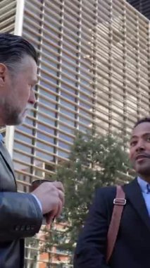 Finans bölgesinde ofis inşaatı hakkında konuşan iki profesyonel iş arkadaşının dikey HD videosu.. 