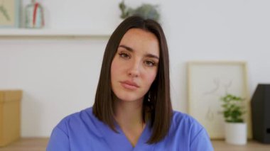 Genç kadın sağlık çalışanlarının POV 'u ofisten video görüşmesi yapıyor. Mavi önlüklü genç hemşire sanal konferans aracılığıyla hastayı dinliyor. Teletıp ve tıbbi yaşam tarzı konsepti.