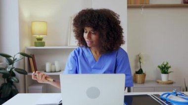 Modern bir muayenehanede dizüstü bilgisayarı üzerinde çalışan bayan bir Latin Amerikalı doktor. Yanında stetoskop ve röntgenleri var. Sağlık hizmeti yaşam tarzı ve iş konsepti