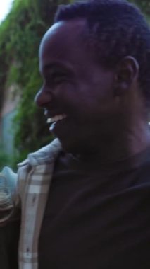 Şehir caddesinde birlikte eğlenen çok ırklı genç arkadaşların dikey HD videosu. Gençlik toplumu, çeşitlilik ve arkadaşlık kavramı.