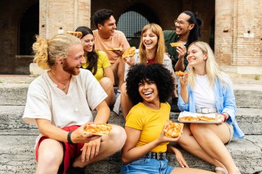 İtalya 'da yaz tatilinin tadını çıkaran, pizza yiyen çok ırklı bir grup turist. Gençlik toplumu ve seyahat yaşam tarzı kavramı