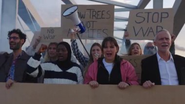 Dünya barışı için yürüyen bir grup aktivist. Çeşitli göstericiler savaş ve şiddeti protesto eden pankartlar ve posterler taşıyorlar. Savaş protestosu konsepti yok.
