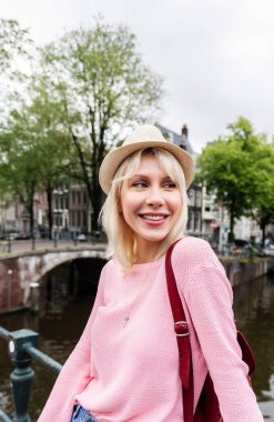 Amsterdam 'da seyahat eden mutlu genç bir kadının dikey portresi. Seyahat kavramı