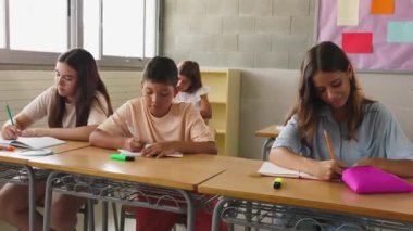 Erkek ve kız öğrenciler ilkokulda sınıfta okuyor. Çocuk eğitim yaşam tarzı konsepti.