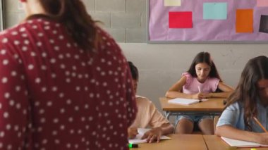 İlkokulda ilkokul öğrencisine asistanlık yapan bayan öğretmen. Eğitim kavramı.