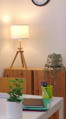 Masaüstü bilgisayarı, masa ve ofis malzemeleri olan parlak bir dairede küçük bir iş yeri. Yurt içi iç işleri çalışma alanı.