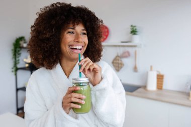 Melez ırkın portresi. Güzel bir genç kadın. Sabahları sağlıklı yeşil meyve suyu içiyor. Güzel bir milenyum kızı Biyolojik Smoothie Shake 'in tadını çıkarıyor