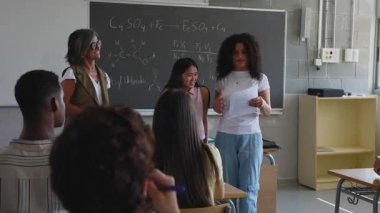 Lise öğrencileri kimya projelerini öğretmenlerinin ve sınıf arkadaşlarının önünde sunuyorlar. Eğitim yaşam tarzı kavramı