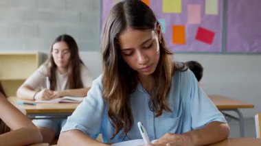 Mutlu öğrenci notlar yazıyor ve derste kameraya gülümsüyor. Eğitim yaşam tarzı kavramı