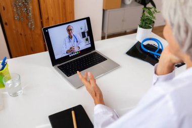 İki profesyonel üst düzey sağlık çalışanı laptopla video görüşmesi yapıyor. E-öğrenim, iş ve sağlık eğitimi kavramı