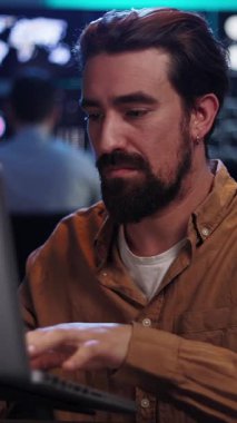 Karanlık ofiste çalışan genç borsa simsarının dikey HD videosu. Finansal yatırım ve teknoloji kavramı