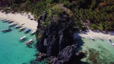Palawan, Filipinler 'deki Yedi Komando sahilinde palmiye ağaçları ve filipino tekneleri olan güzel beyaz kumsal manzarası.. 