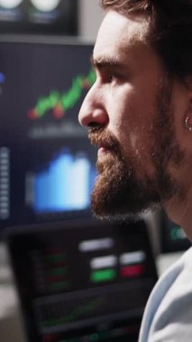 İstatistikleri analiz eden ve borsa ticaretini yürüten finans tüccarının dikey HD videosu.