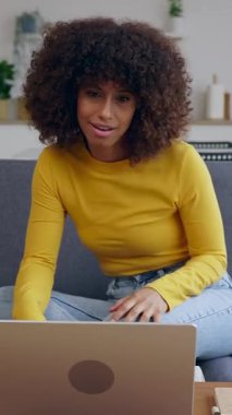 Modern çatı katındaki kanepede dinlenirken arkadaşlarıyla dizüstü bilgisayarla konuşan mutlu bir kadının dikey HD videosu..