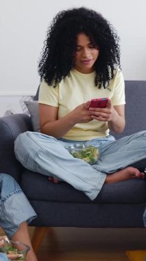 Evde cep telefonu kullanarak eğlenen bir grup genç kızın dikey HD videosu. Milenyum öğrencileri cep telefonu uygulamasında sosyal medya içeriğinin keyfini çıkarırken konuşuyor