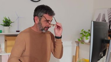 Yetişkin bir iş adamı laptopta çalışıyor, ofis masasında oturuyor. İş konsepti