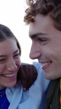 Farklı arkadaşlardan oluşan genç bir grubun eğlendiği dikey HD video. Çok ırklı en iyi arkadaşlar birlikte vakit geçiriyorlar, dışarıda birbirlerini kucaklarken gülüyorlar. Gençlik toplumu kavramı.