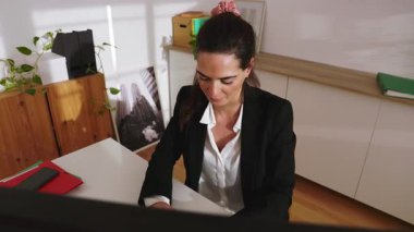 Parlak ofiste çalışan genç ve mutlu bir girişimci kadın. İş ve güçlendirme kavramı