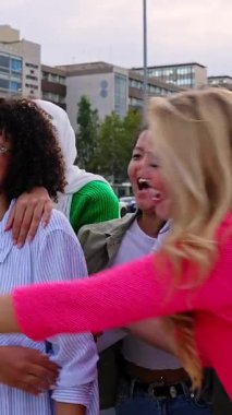 Kendine güvenen bir grup kadının şehir caddesinde eğlenirken çekilmiş dikey HD videosu. Dışarıda birbirine sarılan yedi çok ırklı genç kadın. Gençlik toplumu kavramı