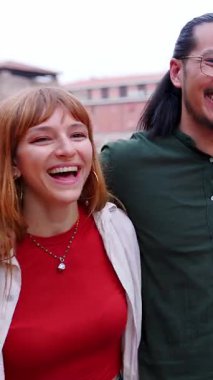 Şehir caddesinde birlikte eğlenen mutlu çok ırklı gençlerin dikey HD videosu. Milenyum turist arkadaşları İtalya 'da yaz tatilinin tadını çıkarıyorlar. Gençlik toplumu kavramı