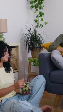 Dikey HD videosu, mutlu genç kız öğrenci oda arkadaşlarının evde buluşup, hikayeler anlatıp, öğle yemeği yiyip, birlikte vakit geçirmelerini gösteriyor. Milenyum dostları oturma odasında konuşuyor.