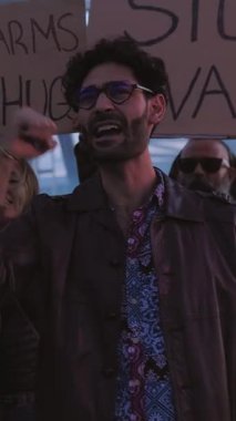 Dikey HD video. Dünyada savaş ve şiddeti protesto eden çeşitli aktivist grupları posterler ve pankartlar taşıyorlar..