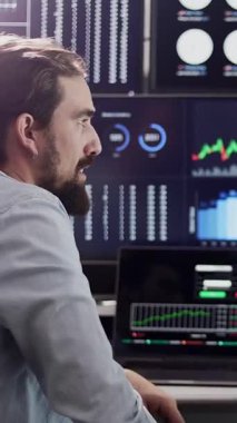 İstatistikleri analiz eden ve borsa ticaretini yürüten finans tüccarının dikey HD videosu.