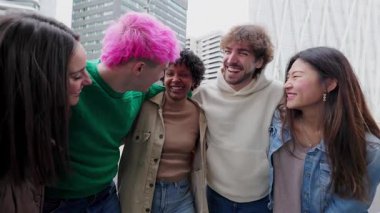 Çok ırklı bir grup genç arkadaş dışarıda gülüp eğleniyorlar. Milenyum kuşağı insanları, şehir caddesinde takılırken birbirlerini kucaklarken eğleniyorlar. Çeşitlilik ve topluluk
