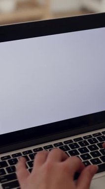 Evde boş beyaz ekranlı dizüstü bilgisayar kullanan tanınmayan genç bir kadının dikey HD videosu