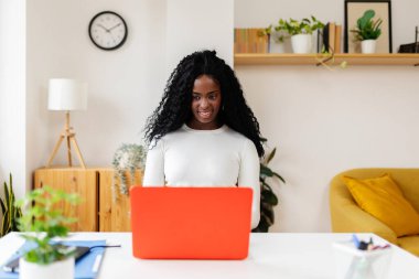 Laptop bilgisayarında çalışan genç bir iş kadını ofis masasında oturuyor. Girişimciler ve ev kavramından uzak çalışanlar