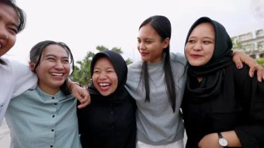 Asyalı bir grup genç bayan arkadaş şehir sokağına gülüyor. Çok ırklı Z nesli öğrenci kızlar dışarıda takılırken eğleniyorlar. Kadın arkadaşlığı ve gençlik toplumu kavramı. 