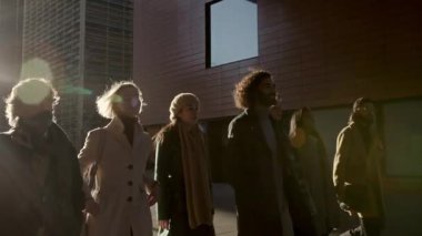 Bir grup işadamı ve iş kadını modern şehirde yürüyor. Başarılı iş adamları takımı.