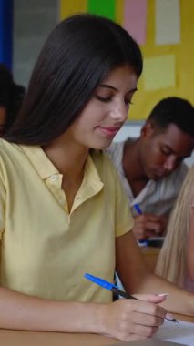 Lisede arka arkaya okuyan çeşitli genç öğrencilerin dikey HD videosu. Eğitim yaşam tarzı ve okul konseptine dönüş.