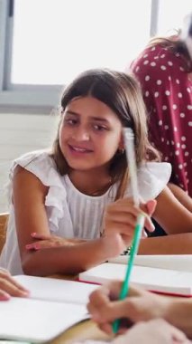 İlköğretim okulunda birlikte eğitim gören ve egzersiz yapan genç kızların dikey HD videosu. Çocuk eğitimi konsepti.