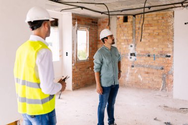 İnşaat alanındaki ilerlemeyi değerlendiren mühendisler sonraki adımları tartışıyor, projenin tamamlanmasını sağlıyorlar. Mühendislik ve mimari kavramı