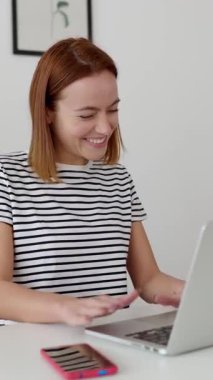 Genç ve mutlu bir iş kadınının dizüstü bilgisayarında görüntülü konuşma yaptığı dikey HD video. Bağımsız ve girişimci insan kavramı